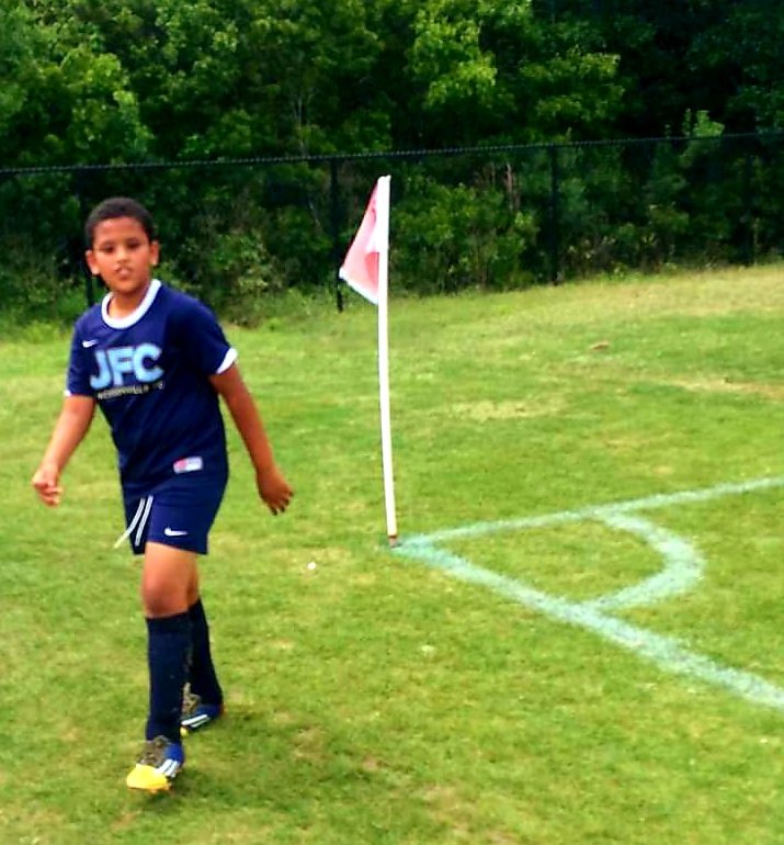 Mid-game, near the corner flag. The shirt fits, the sprint comes naturally.