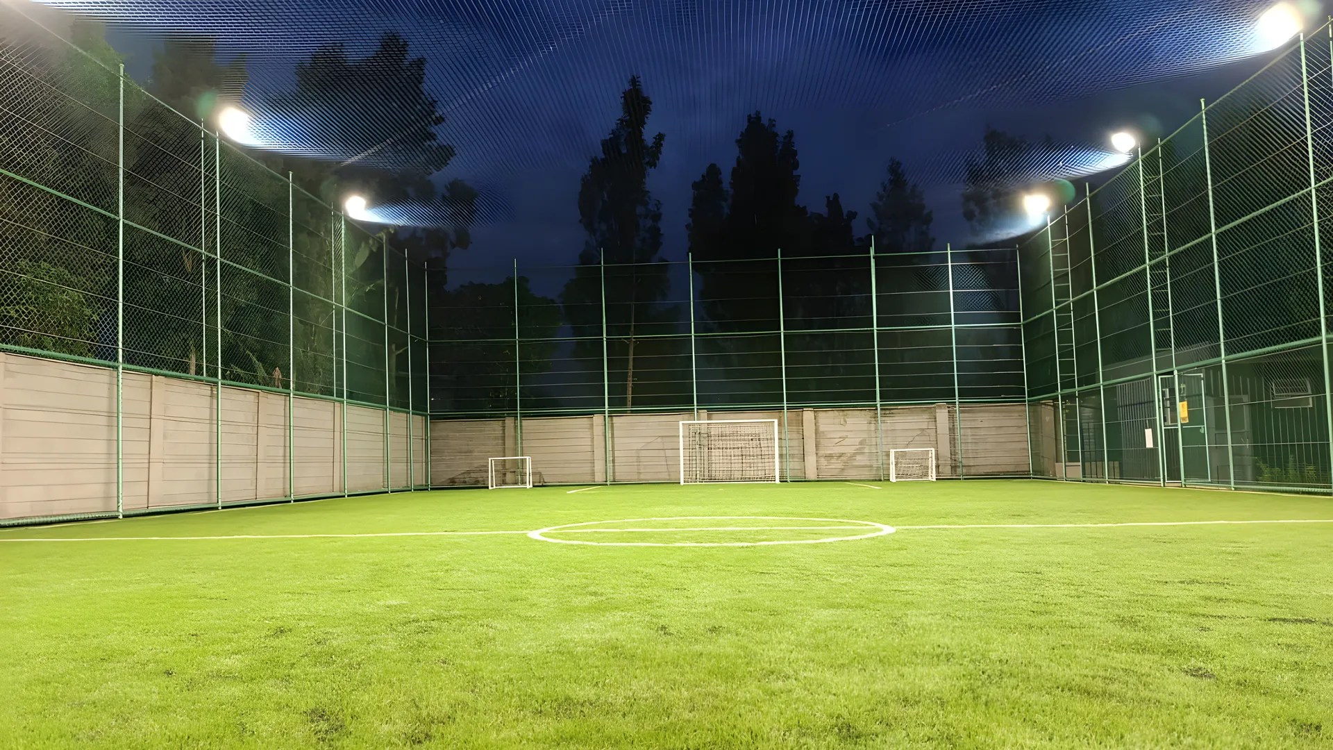 Floodlit pitch at PAKTB Grace Sports Centre viewed from midfield